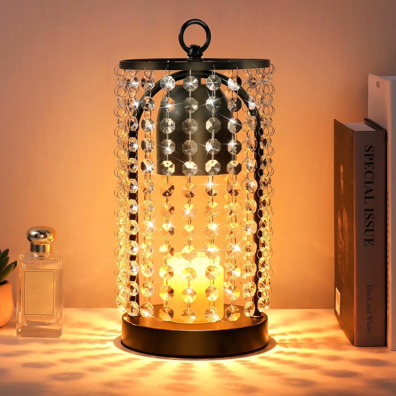 Decorative lamp with beaded design on a table next to a book and a bottle.