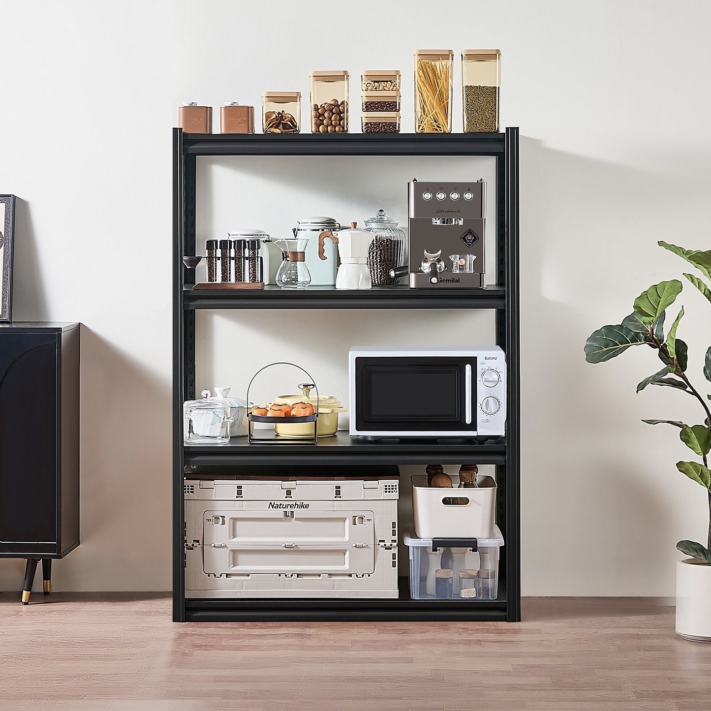 A 4-tier black storage shelf in a garage setting, with various items placed on it, such as a microwave, storage boxes, and decorative items.