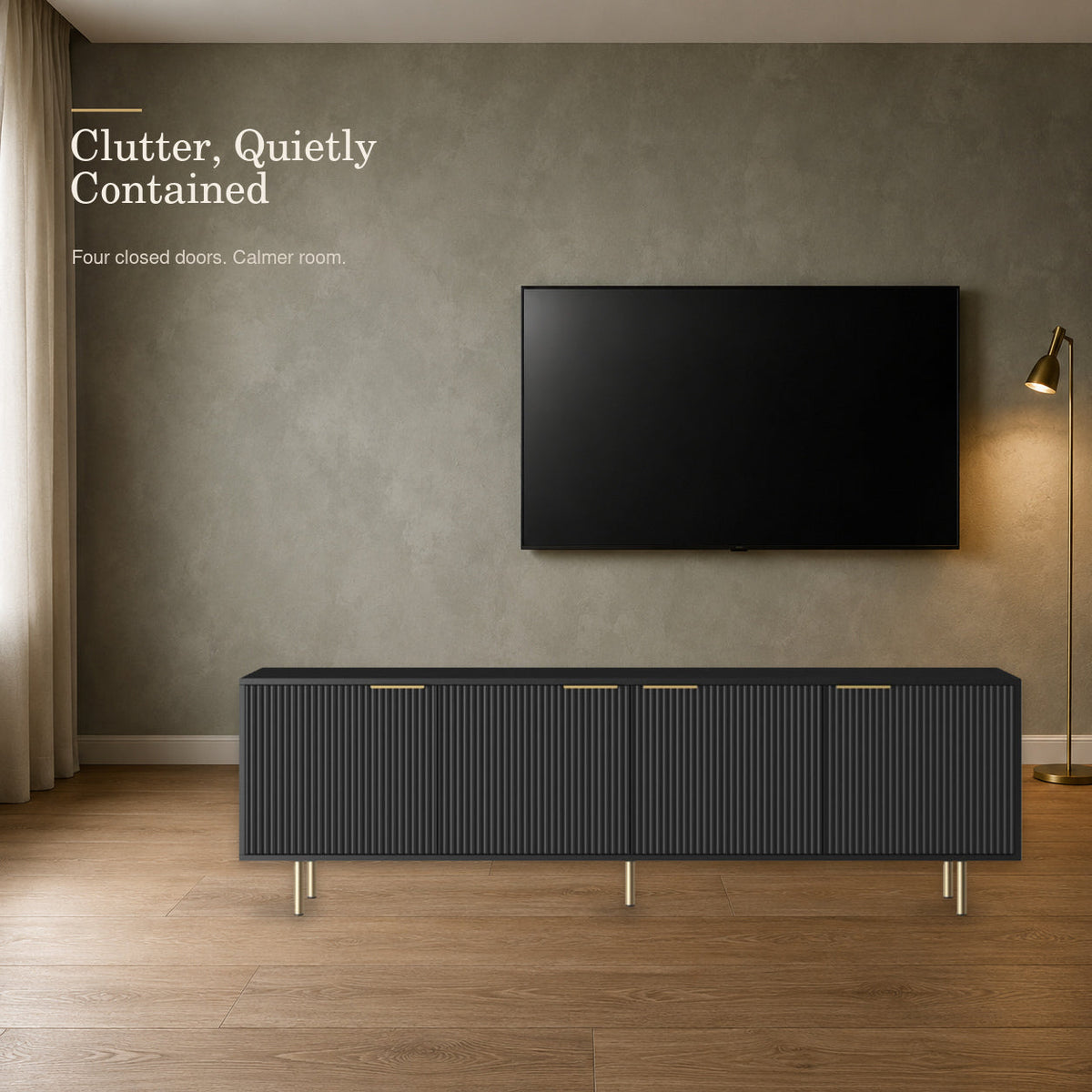 Black fluted media console with four closed doors in a sage living room