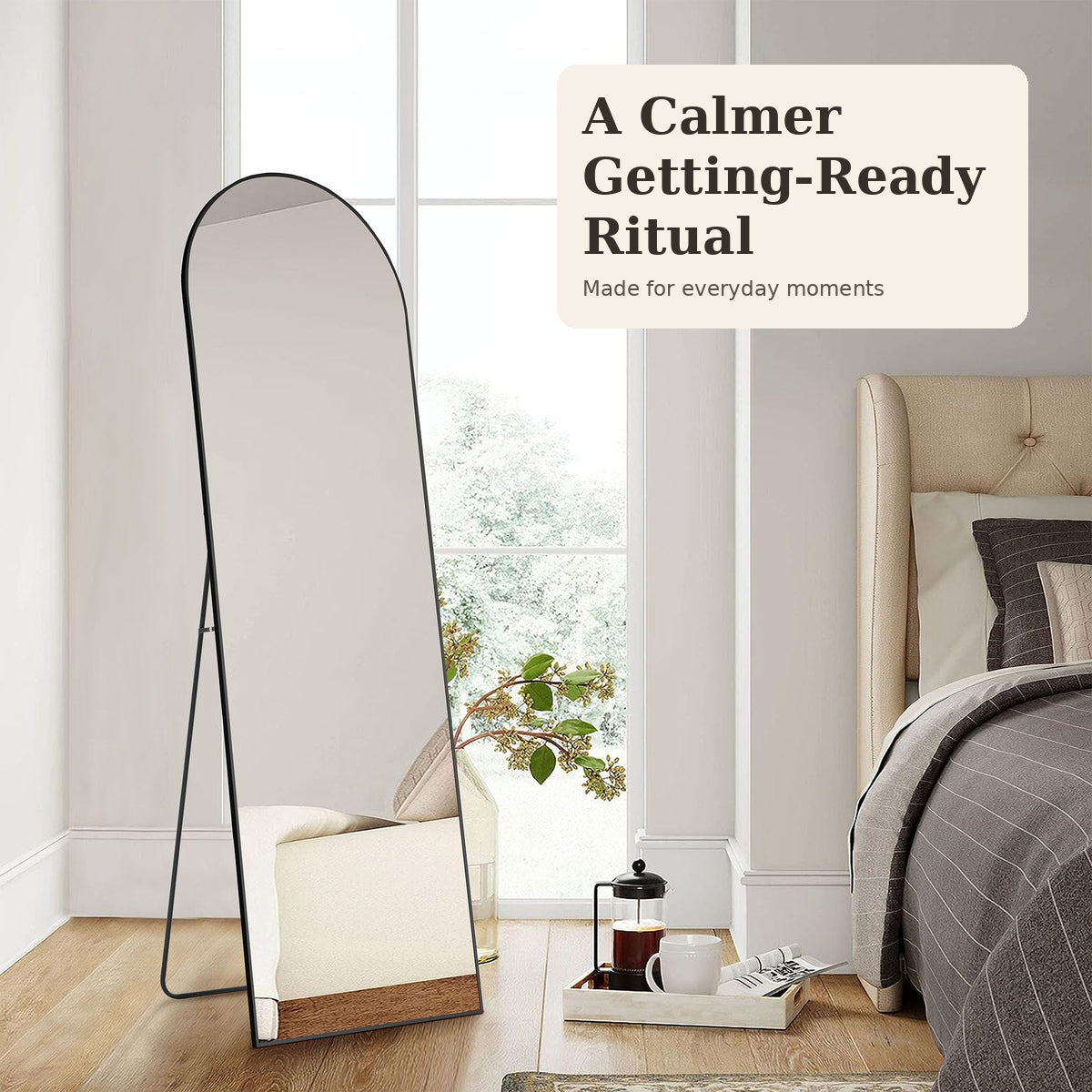 Black arched full-length mirror in a calm bedroom