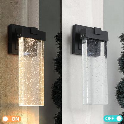 Two outdoor wall lights, one on and one off, on a textured wall background.