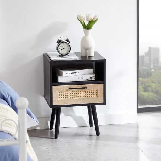 Black nightstand with a wooden drawer in a room with a cityscape view.