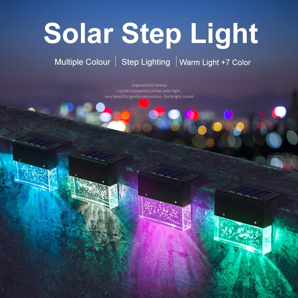 Solar step lights emitting colorful light on a stone surface with a blurred cityscape background.