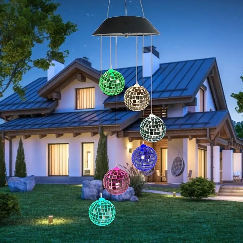 Colorful disco ball wind chime in front of a house at night