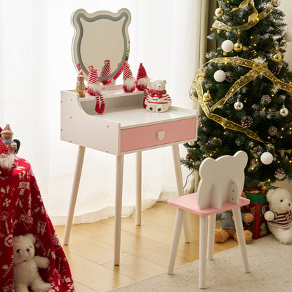 A white kids' dressing table set with a mirror and storage, accompanied by a pink stool, set against a room with a Christmas tree and festive decorations.