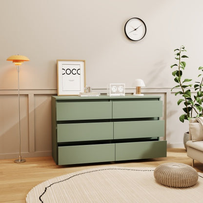 A luxury green 6-drawer dressing table with gold handles, placed in a room with a modern interior design.