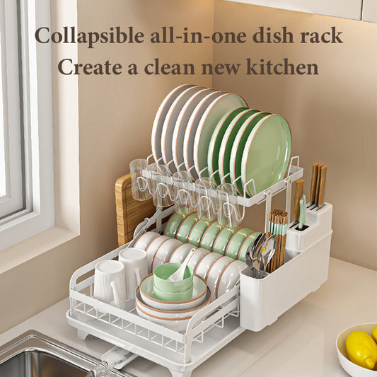 A white collapsible all-in-one dish rack filled with plates, cups, and kitchen utensils, positioned over a sink.