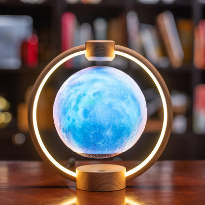 A levitating blue moon lamp with a 3D printed surface, surrounded by a circular LED light, mounted on a wooden base.