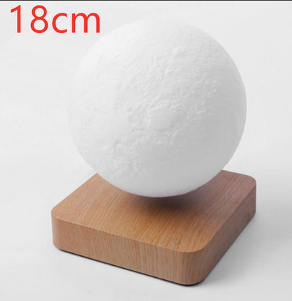 A 3D printed white moon lamp levitating above a wooden base, with a touch sensor on the side.