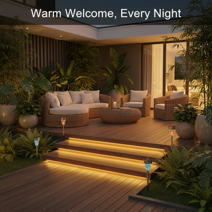 Outdoor patio area with seating, plants, and warm lighting at night.