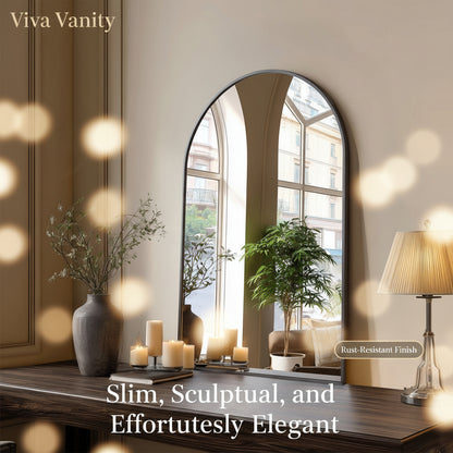 Arched mirror on a wooden console table with decorative items in a room.