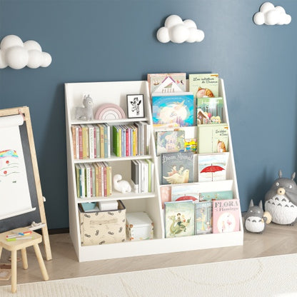 A white children's bookcase with four tiers, featuring books, toys, and decorative items, positioned in a room with a blue wall, a easel, and a teddy bear.