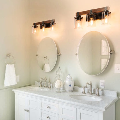 A vintage three-lamp farmhouse bathroom wall sconce installed above a bathroom vanity, featuring a classic black metal frame and three bulb sockets.