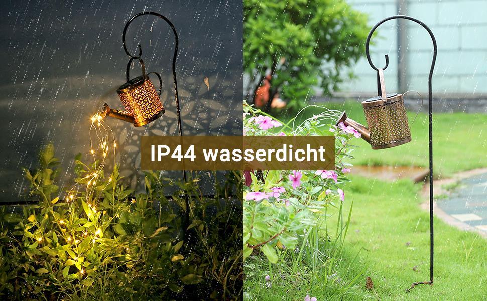 Garden ornament with watering can design in a garden setting, featuring IP44 weather resistance label.