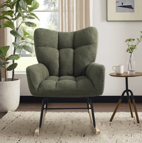 A modern rocking accent chair with a wood and metal frame and deep green teddy fabric upholstery, positioned in a room near a window with plants and a side table.