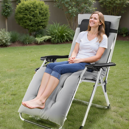 Woman sitting in a gray reclining chair on a grassy area with plants in the background
