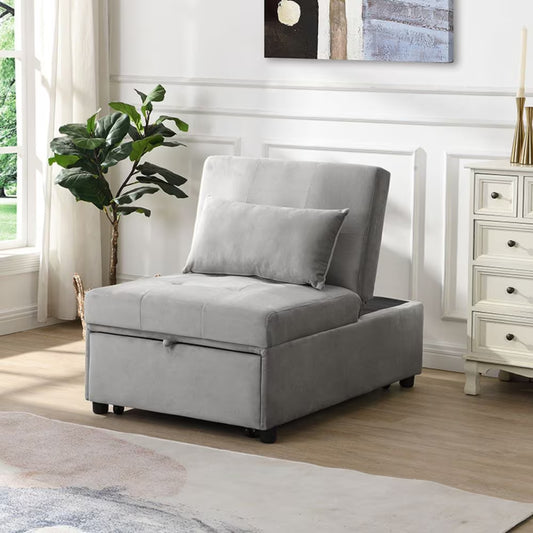A graphite grey linen-blend folding ottoman sofa bed with a cushion on top, situated in a well-lit room with a white wall and a plant to the side.
