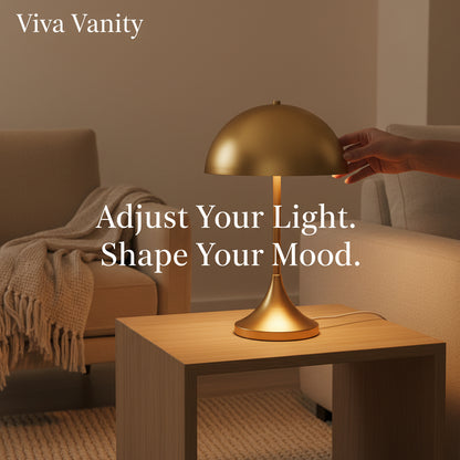 A dome-shaped 2-light metal table lamp with a sleek, curved shade, placed on a white table in a room with a minimalist decor.