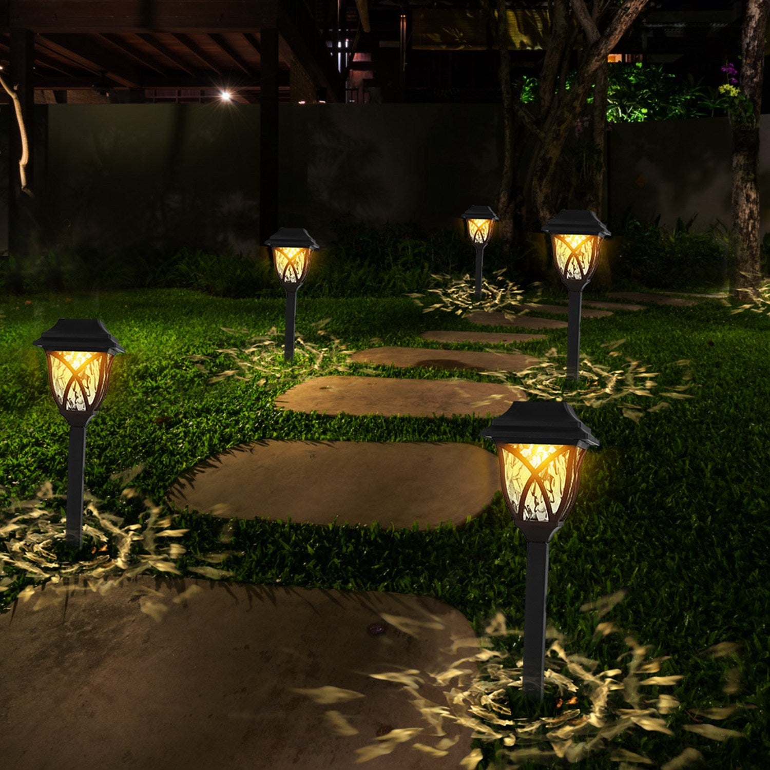 Solar garden lights illuminating a pathway in a garden at night.