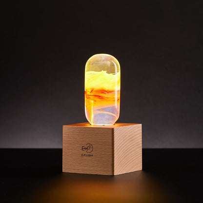 A vintage wooden table lamp with an LED flame bulb, placed on a square base, emitting a warm yellow glow.