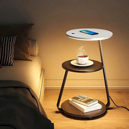 Modern side table with a smartphone, cup of coffee, and books in a bedroom setting.