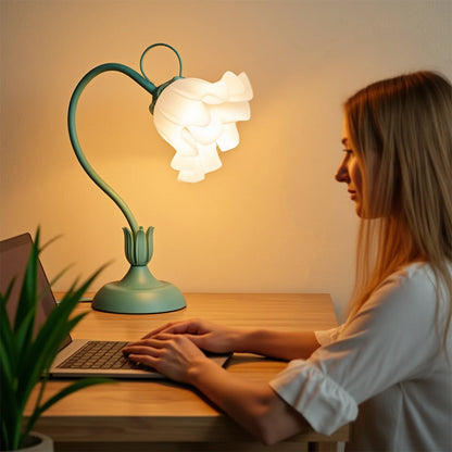 Woman working on a laptop under a decorative lamp with a heart-shaped design.