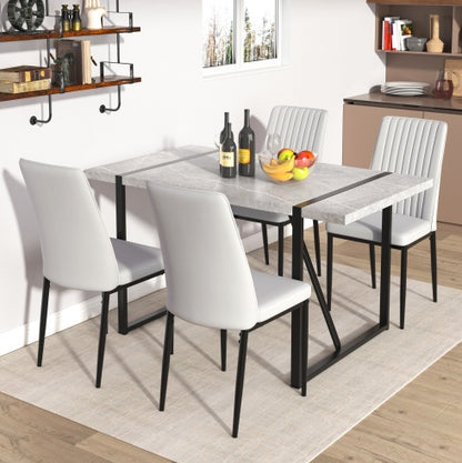 A modern rectangular dining table with a gray tabletop and black metal legs, surrounded by four white chairs, set in a kitchen environment.