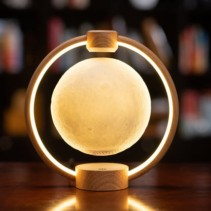 A levitating blue moon lamp with a 3D printed surface, surrounded by a circular LED light, mounted on a wooden base.