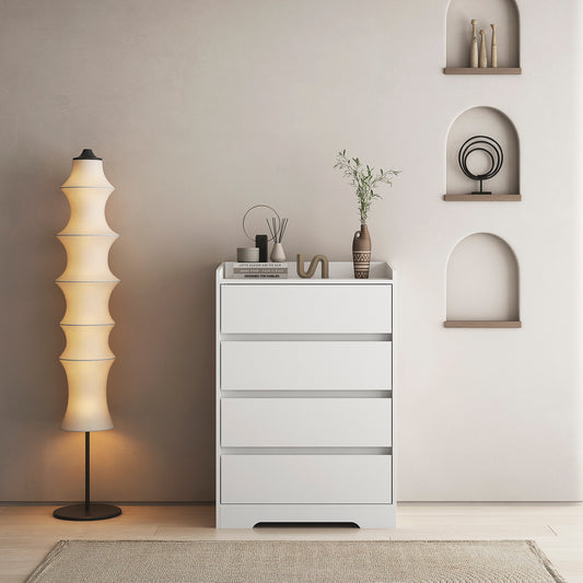 A white handleless dresser with four drawers placed in a room with a minimalist design, featuring a floor lamp and decorative items on the top surface.