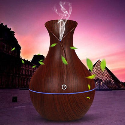 A vase-shaped LED ultrasonic aroma humidifier and essential oil diffuser emitting mist, with multicolor LED lighting and a wooden design.