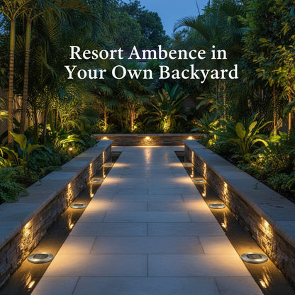 Evening view of a landscaped pathway with lighting, surrounded by tropical plants.