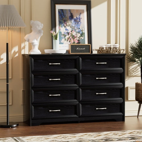 A black modern 3-drawer bedroom chest with 8 drawers, metal pulls, and placed in a room setting with decorative items on top.