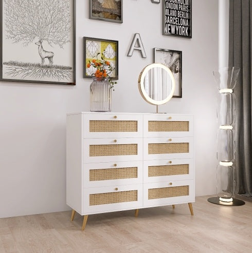 A white color 8-drawer chest of drawers with rattan drawer faces and golden legs and handles, placed in a room with a variety of decorations.