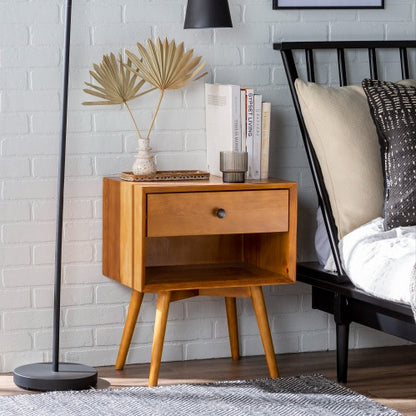 Wooden nightstand with decorative items next to a bed in a bedroom setting.