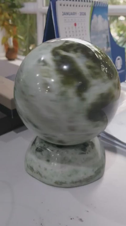 Close-up video of 6 inch natural green marble sphere with matching base, polished stone decor from Vietnam