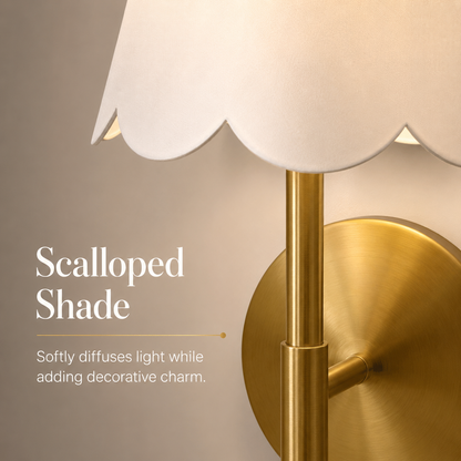 Close-up of scalloped white fabric shade and brass wall sconce finish