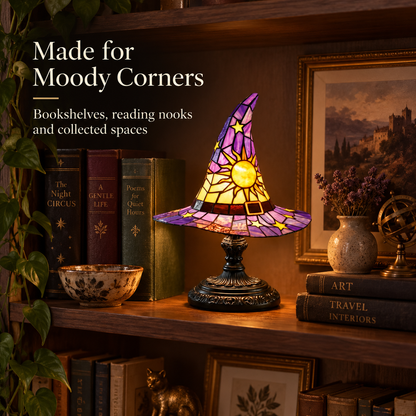 Witch hat accent lamp styled on a moody walnut bookshelf with books greenery and framed art