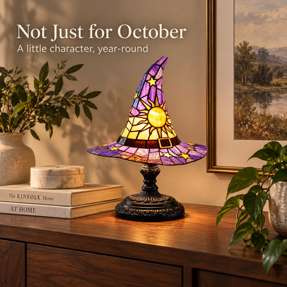 Witch hat accent lamp styled as year-round decor on a warm walnut console with neutral books and greenery